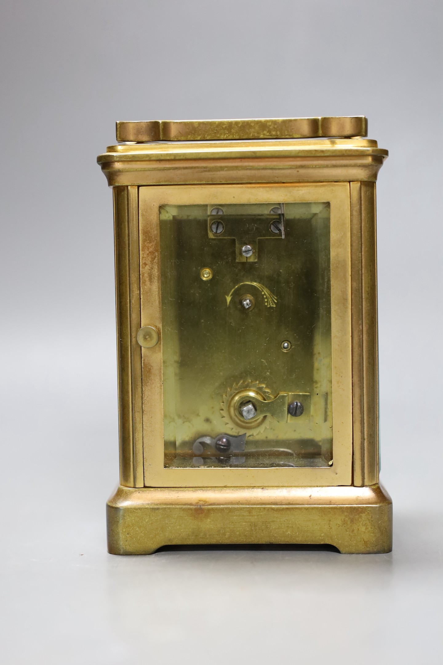A leather cased brass carriage timepiece. 13cm tall